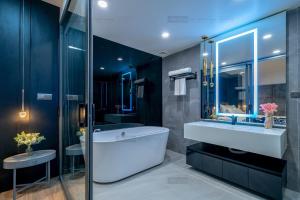 ein Badezimmer mit einer Badewanne, einem Waschbecken und einem Spiegel in der Unterkunft ELITE HOME in Tuy Hoa