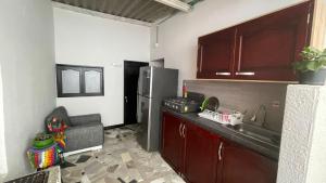 a kitchen with a stainless steel refrigerator and a couch at Alojamiento Mamá Juana in Ríohacha