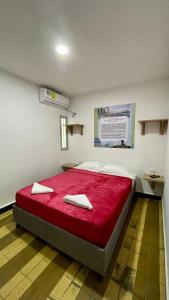 1 dormitorio con 1 cama grande con sábanas rojas en Alojamiento Mamá Juana, en Ríohacha