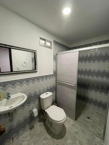 a bathroom with a toilet and a sink at Alojamiento Mamá Juana in Ríohacha