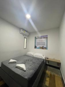 1 dormitorio con 1 cama con 2 toallas en Alojamiento Mamá Juana, en Ríohacha