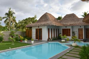 a villa with a swimming pool and a resort at Balai Cinta in Panglao Island