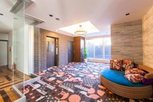 a large room with a blue couch on a rug at GLISTEN in Otaru