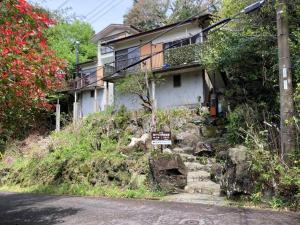 ein Haus auf einem Hügel mit einem Schild davor in der Unterkunft 海テラス伊豆高原Ａ in Yawatano
