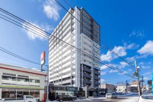 un edificio blanco alto en una calle de la ciudad en GREE en Otaru