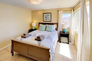 a bedroom with a large bed with two towels on it at Asbury Haven in San Diego