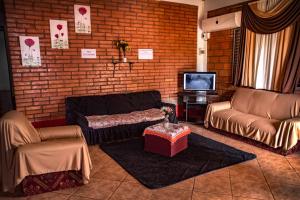 sala de estar con sofás y pared de ladrillo en Iguazú Alojamiento "La casa" en Puerto Iguazú