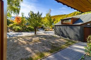 una casa con un albero in mezzo a un vialetto di Arrow Getaway - Arrowtown Holiday Home ad Arrowtown