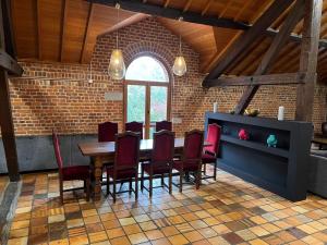 Luxurious Mansion in N blon le Pierreux with Pool في Ouffet: غرفة طعام مع طاولة وكراسي حمراء