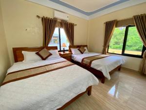 峰牙的住宿－Phong Nha Orient Hotel，一间卧室设有两张床和窗户。