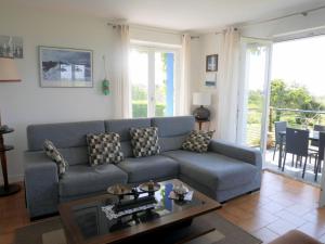 a living room with a blue couch and a table at Holiday home with sea views, Lampaul-Plouarzel in Lampaul-Plouarzel