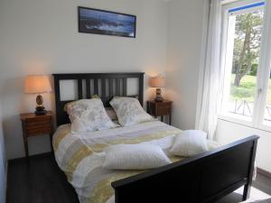 1 dormitorio con 1 cama con 2 almohadas en Holiday home with sea views, Lampaul-Plouarzel en Lampaul-Plouarzel