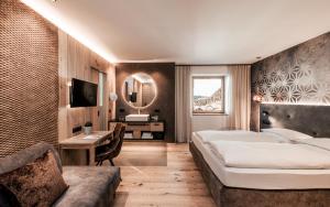 1 dormitorio con cama, escritorio y espejo en Seehotel Panorama Relax, en Resia