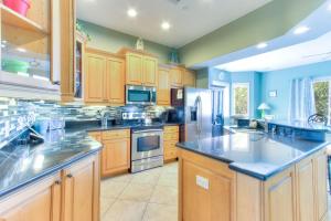 a large kitchen with wooden cabinets and stainless steel appliances at Bayway Luxury Suites 1 townhouse in Clearwater Beach