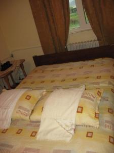 a bed with two pillows on it with a window at Lary Hostel in Suceava