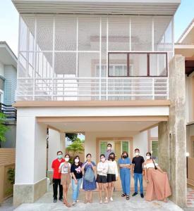 un grupo de personas parados frente a una casa en Hoteru House Ranong 1 - โฮเตรุ เฮ้าส์ ระนอง en Ranong