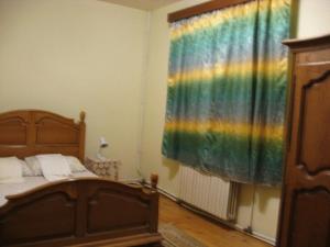 a bedroom with a bed and a rainbow curtain at Lary Hostel in Suceava