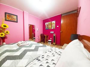 a bedroom with two beds and pink walls at Samay Wasi - Aeropuerto in Lima