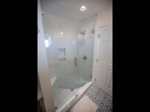 a bathroom with a shower with a glass door at Three Girls in Holden Beach +51 photos