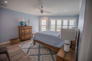 a bedroom with a bed and a table with a lamp at Three Girls in Holden Beach