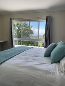 a bedroom with a large bed with a large window at Ocean View Oasis, Coffs Harbour in Coffs Harbour