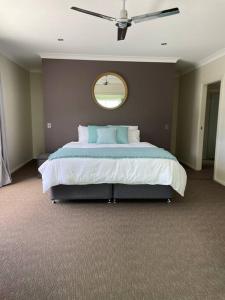 a bedroom with a large bed with a mirror on the wall at Ocean View Oasis, Coffs Harbour in Coffs Harbour