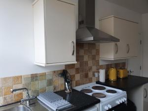 een keuken met een wit fornuis en een wastafel bij One Bed Apartment With Sofa Bed in Llandudno