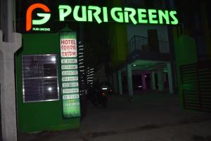 a sign in front of a store at night at HOTEL PURI GREENS in Puri
