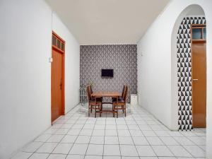 a dining room with a table and chairs at SPOT ON 91117 Sriwijaya Residence Syariah in Bandung
