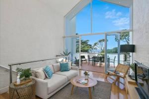 - un salon avec un canapé et une table dans l'établissement Lonnie Beach View Apartment, à Point Lonsdale