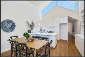 a kitchen and dining room with a table and chairs at Lonnie Beach View Apartment in Point Lonsdale