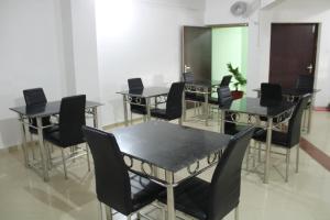 eine Gruppe von Tischen und Stühlen in einem Zimmer in der Unterkunft HOTEL PURI GREENS in Puri