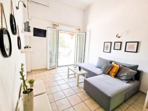 a living room with a couch and a large window at Haris apartments in Koukounaries