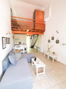 sala de estar con sofá azul y escalera en Haris apartments, en Koukounaries