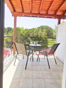 un patio con tavolo e sedie sul balcone. di Haris apartments a Koukounaries
