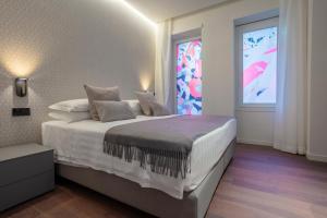 um quarto com uma grande cama branca e uma janela em Sant'Ambrogio Apartments em Milão