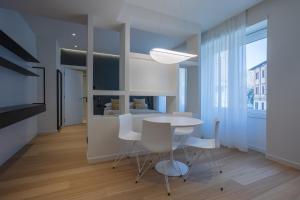 kuchnia i jadalnia ze stołem i krzesłami w obiekcie Sant'Ambrogio Apartments, Reception h24 w Mediolanie