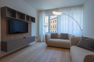 salon z kanapą i telewizorem z płaskim ekranem w obiekcie Sant'Ambrogio Apartments, Reception h24 w Mediolanie