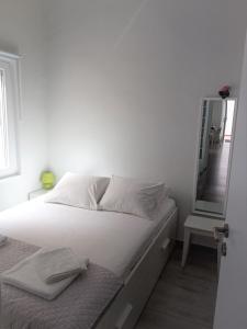 a bedroom with a white bed with a mirror at Sea U in Chania Town