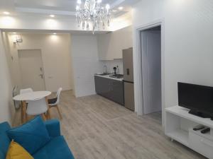 Una sala de estar con un sofá azul y una mesa. en Natalie appartement 41, en Tiflis
