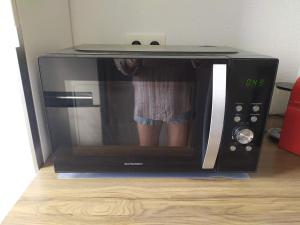 a young child standing inside a microwave oven at Au levant de Marie in Gaillac