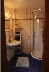 a bathroom with a sink and a shower at Ferienwohnung Härtings Hygge in Obernkirchen