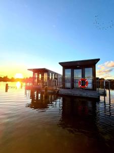 a house on a dock on a body of water at Domki na wodzie Jastarnia - Houseboat in Jastarnia