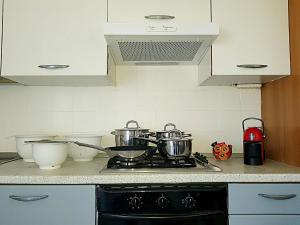 a kitchen with a stove with pots and pans on it at Marotta, 300 mt dal mare, Sea & City Apartments, Sea&Business, Wi-Fi fibra, parking, 3 camere, 11 letti in Marotta