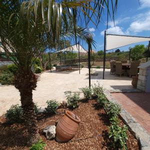 un jardín con una palmera y un patio en Paradisos Villa - Chania, Crete, en Litsárdha