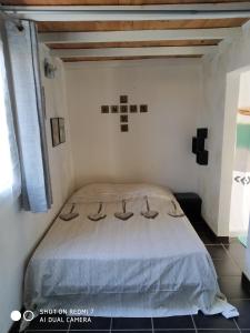1 dormitorio con 1 cama en una habitación blanca en Les chambres d hôtes de Jade en Pujaut