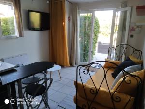 a small living room with a table and a couch at Les chambres d hôtes de Jade in Pujaut