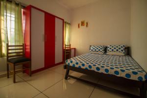 a bedroom with a bed and a chair in it at Bachan's Casa in Cherai Beach