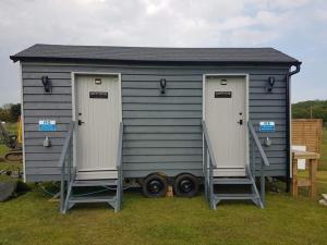 um barracão cinzento com duas portas e duas rodas em Two Jays Farm em Norwich