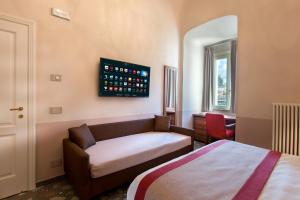 a bedroom with a bed and a couch and a desk at Dimora del Leone Gaeta in Gaeta